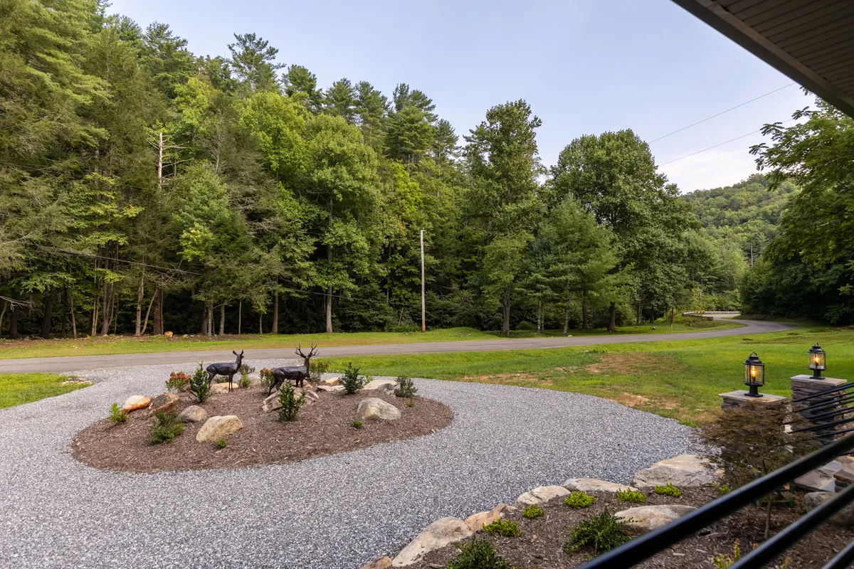 A landscaped gravel circle with decorative deer statues sits amidst lush green trees, creating a tranquil spot for nature walks, birdwatching, or simply enjoying the outdoors with a morning coffee or evening stargazing.